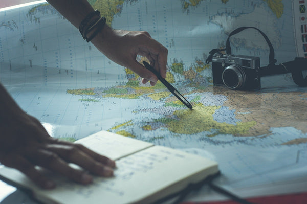 A notepad with a map and a camera in the background
