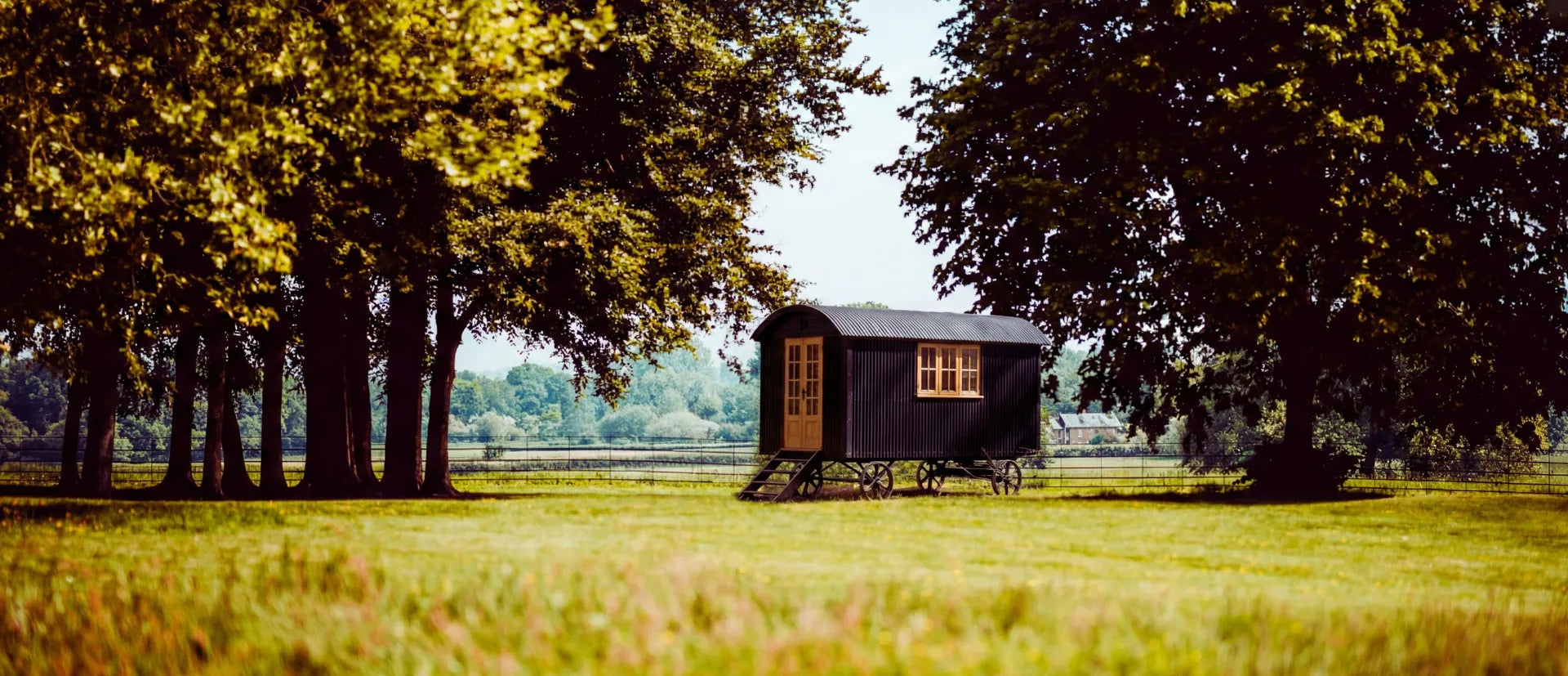 Shepherd hut in a field with trees